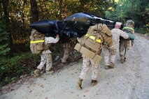 Six Marines with Improved Ribbon Bridge Platoon,  8th Engineer Support Battalion, 2nd Marine Logistics Group carry a zodiac boat to the command operations center while wearing weighted packs during a field exercise aboard Camp Lejeune, N.C., Oct. 24, 2013. Marines had several hours to find their coordinates during land navigation training and return before their time was up. After completion of the day portion of land navigation training, the platoon was given four more coordinates to find at night.