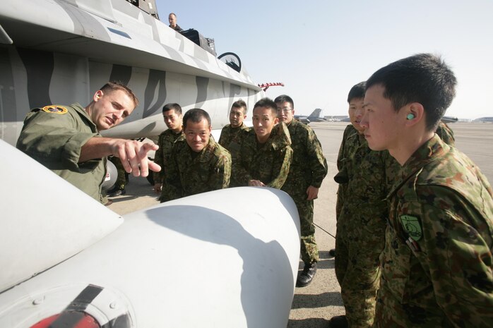 Capt. Sean Roberts, a FA-18/D Hornet pilot with Marine All Weather Fighter Attack Squadron 224, points out different parts of a FA-18/D to members of the Japan Ground Self Defense Force during a recent visit to Marine Corps Air Station Iwakuni, Japan, Feb. 28, 2013. The JGSDF soldiers visited MCAS Iwakuni to learn more about the Marine Corps lifestyle and to improve on their English-speaking skills. This visit was a follow up to the yearly JGSDF English Seminar.