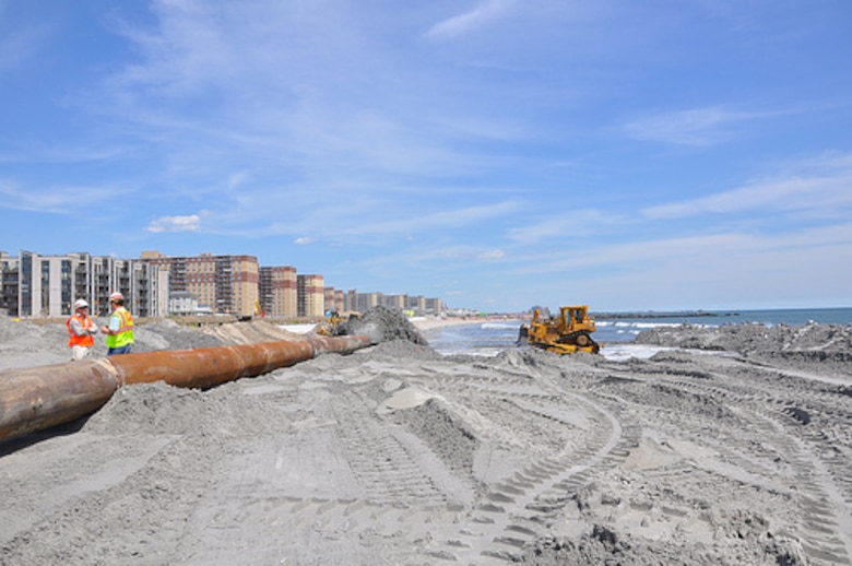 U.S. Army Corps of Engineers personnel discuss beach renourishment activities at the site of active sand placement work in the Rockaways August 15, 2013. Post-Sandy sand placement activities are underway at Rockaway Beach in Queens, NY as part of a project placing roughly 3.5 million cubic yards onto the beach to help reduce risks from future storms