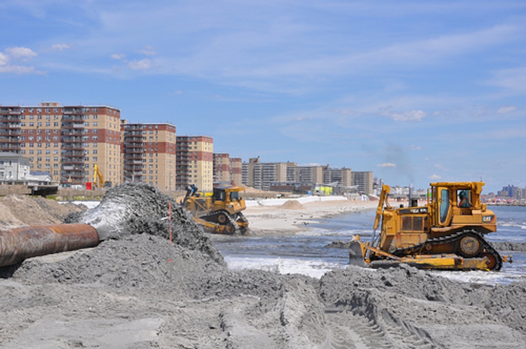 A sand and water slurry mixture pumps onto Rockaway Beach on August 15, 2013 as part of beach renourishment efforts there. The angle shows the severely eroded areas where sand will be placed next as well as some of the densely populated areas where the sand being placed will help to reduce risk from future storms. Post-Sandy sand placement activities are underway at Rockaway Beach in Queens, NY as part of a project placing roughly 3.5 million cubic yards onto the beach to help reduce risks from future storms.