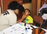 A youth group volunteer paints her brother’s face during the harvest fest Oct. 26, 2013, on Andersen Air Force Base, Guam. The event, which was hosted by chapel members, had several activities including bounce houses, face painting, dunking booths and water games. (U.S. Air Force photo by Senior Airman Cierra Presentado/Released)