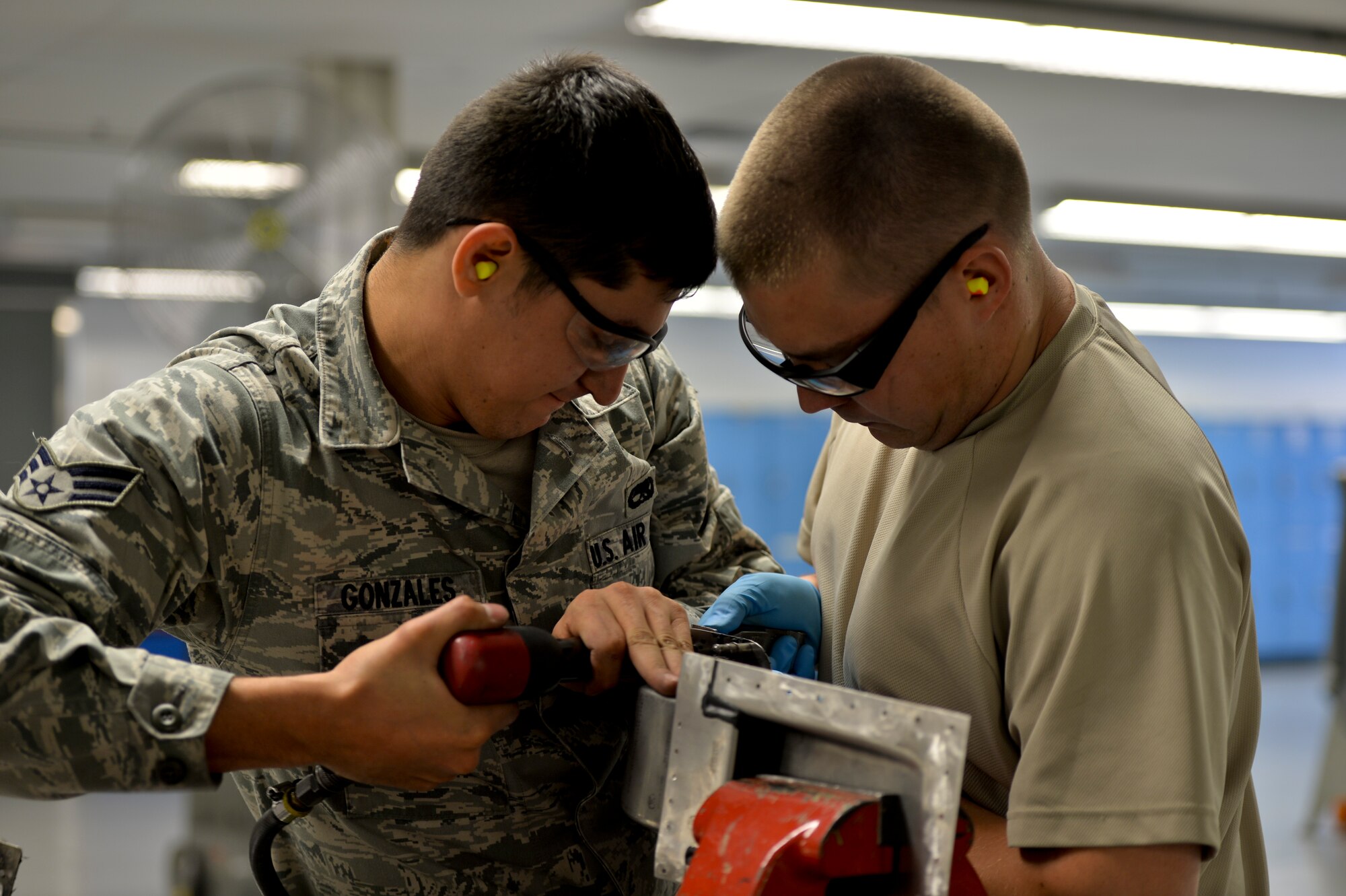 Senior Airman Sergio Gonzalez and Airman 1st Class Christopher Braun, 1st Special Operations Equipment Maintenance Squadron aircraft structural maintenance technicians, install rivets on a C-130 aft nacelle at Hurlburt Field, Fla. Oct. 24, 2013. The aircraft nacelle is a housing which holds engines. (U.S. Air Force Photo/ Staff Sgt. John Bainter)