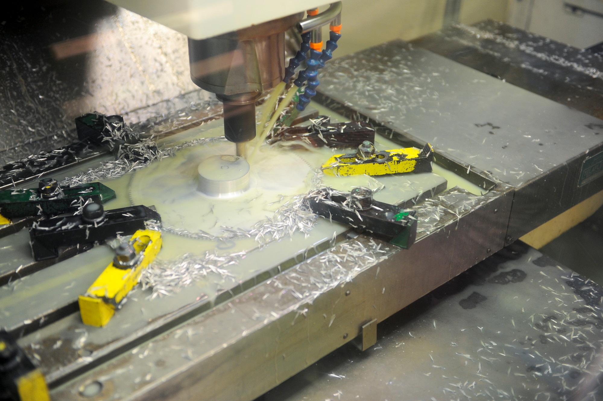 The vertical machining center machines a gear for aircraft testing at Hurlburt Field, Fla., Oct. 24, 2013. The vertical machining center uses liquid to keep the metal cool during the process. (U.S. Air Force photo/Airman 1st Class Jeff Parkinson)