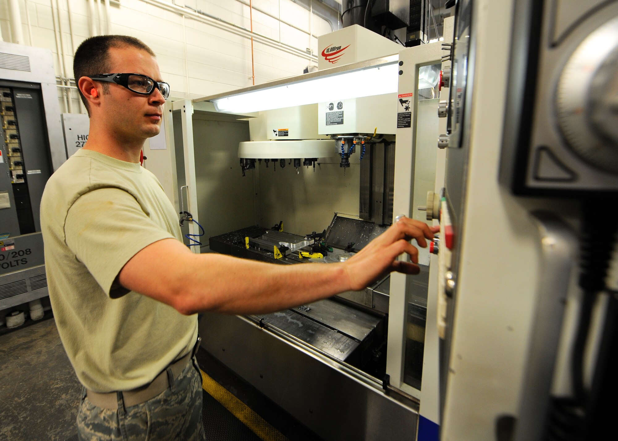 Staff Sgt. James All, 1st Special Operations Equipment Maintenance Squadron aircraft metals technology craftsman, enters coordinates into the vertical machining center prior to machining a gear for engine testing at Hurlburt Field, Fla., Oct. 24, 2013. The vertical machining center uses rotary cutters to remove material from a work piece. (U.S. Air Force photo/Airman 1st Class Jeff Parkinson)