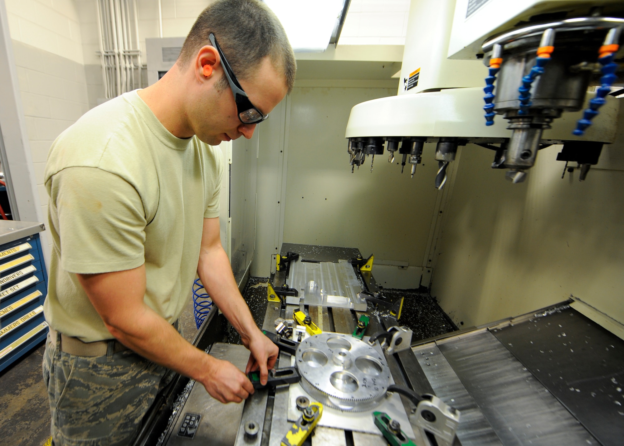 Staff Sgt. James All, 1st Special Operations Equipment Maintenance Squadron aircraft metals technology craftsman, places clamps prior to machining a new gear at Hurlburt Field, Fla., Oct. 24, 2013. . Placing clamps in the incorrect positions can interfere with the machining process. (U.S. Air Force photo/Airman 1st Class Jeff Parkinson)