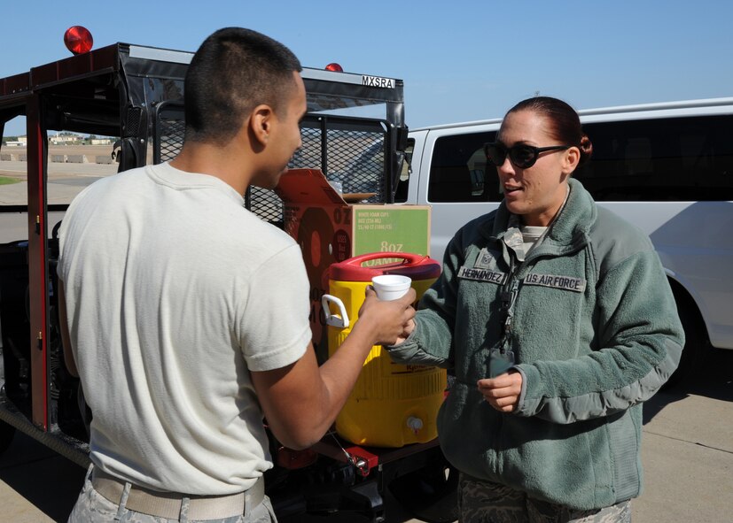 Master Sgt. Christina Hernandez, right, 2nd Aircraft Maintenance Squadron first sergeant gives Airman 1st Class Manuel Figueroa, 2nd Munitions Squadron armament flight technician, a sports drink on Barksdale Air Force Base, La., Oct. 25, 2013. Base first sergeants drove around base delivering food to Airmen working extended hours. (U.S. Air Force photo/Senior Airman Jospeh A. Pagán Jr.)