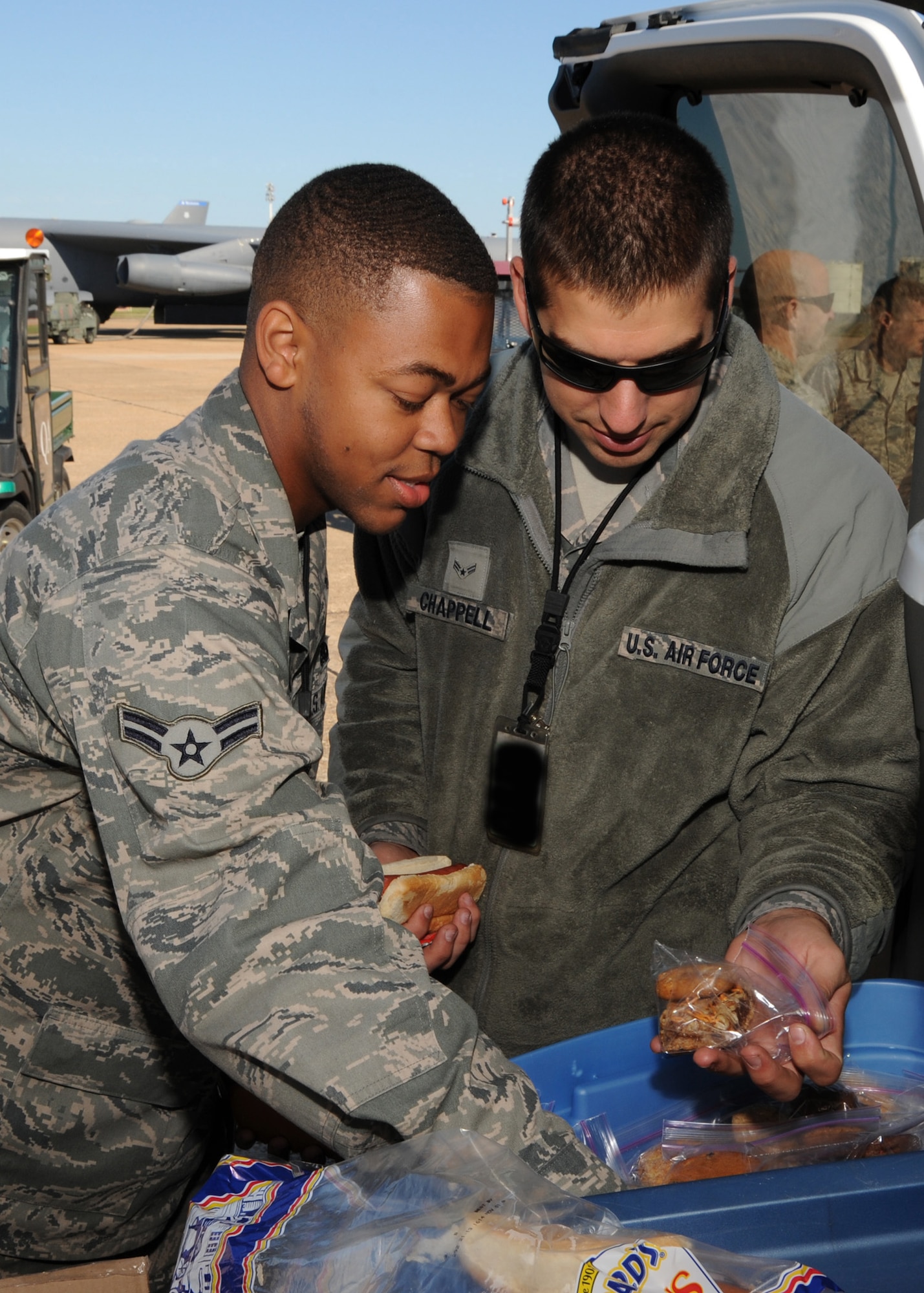 Airmen 1st Class Irvin Mcarthur and Joshua Chappell, 2nd Aircraft Maintenance Squadron, grab cookies from the back of a van on the flightline at Barksdale Air Force Base, La., Oct. 25, 2013. Mcarthur and Chappell took a break to grab a quick bite to eat during a 12-hour shift. (U.S. Senior Airman Joseph A. Pagán Jr.)