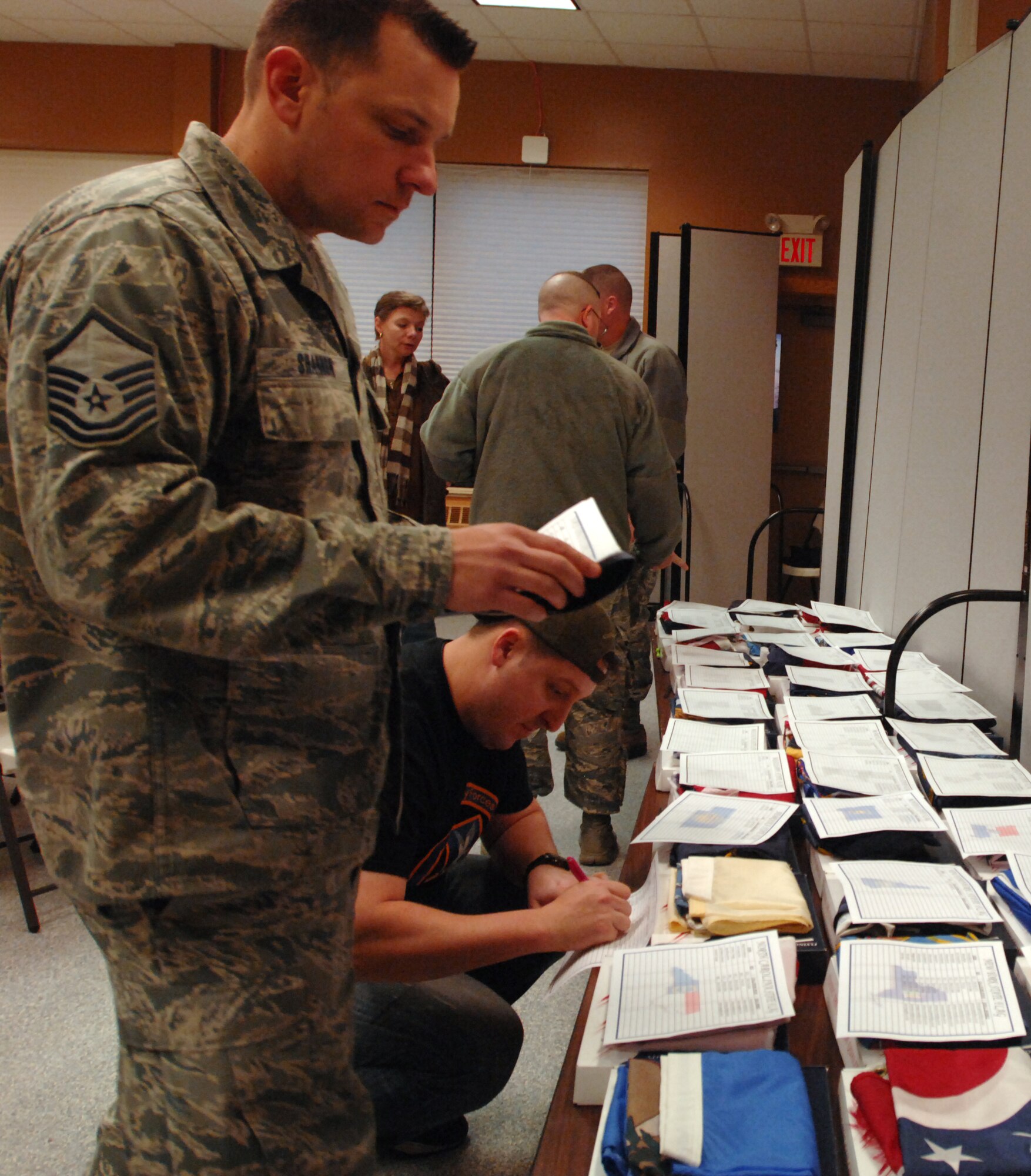 Master Sgt. Daniel Shannon, 319th Air Base Wing Flight Safety NCO-in-charge, and Master Sgt. Frank Galbraith, 319th Security Forces Squadron acting first sergeant, arrange state flags at the Pancake Breakfast and Flag Auction Oct. 25, 2013, at the Prairie Rose Chapel’s Sven’s Den on Grand Forks Air Force Base, N.D. Proceeds from the event will benefit the upcoming 2013 Annual Awards Ceremony. (U.S. Air Force photo/Staff Sgt. Susan L. Davis)