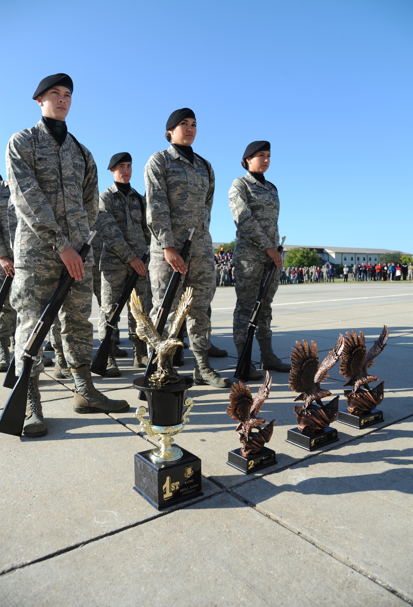 Members of the 338th Training Squadron drill team stand behind their trophies following the awards presentation ceremony of the 81st Training Group drill down competition Oct. 25, 2013, at the Levitow Training Support Facility, Keesler Air Force Base, Miss.  The 338th TRS was the overall winner of the drill down and placed first in the open ranks and regulation competition.    (U.S. Air Force photo by Kemberly Groue)