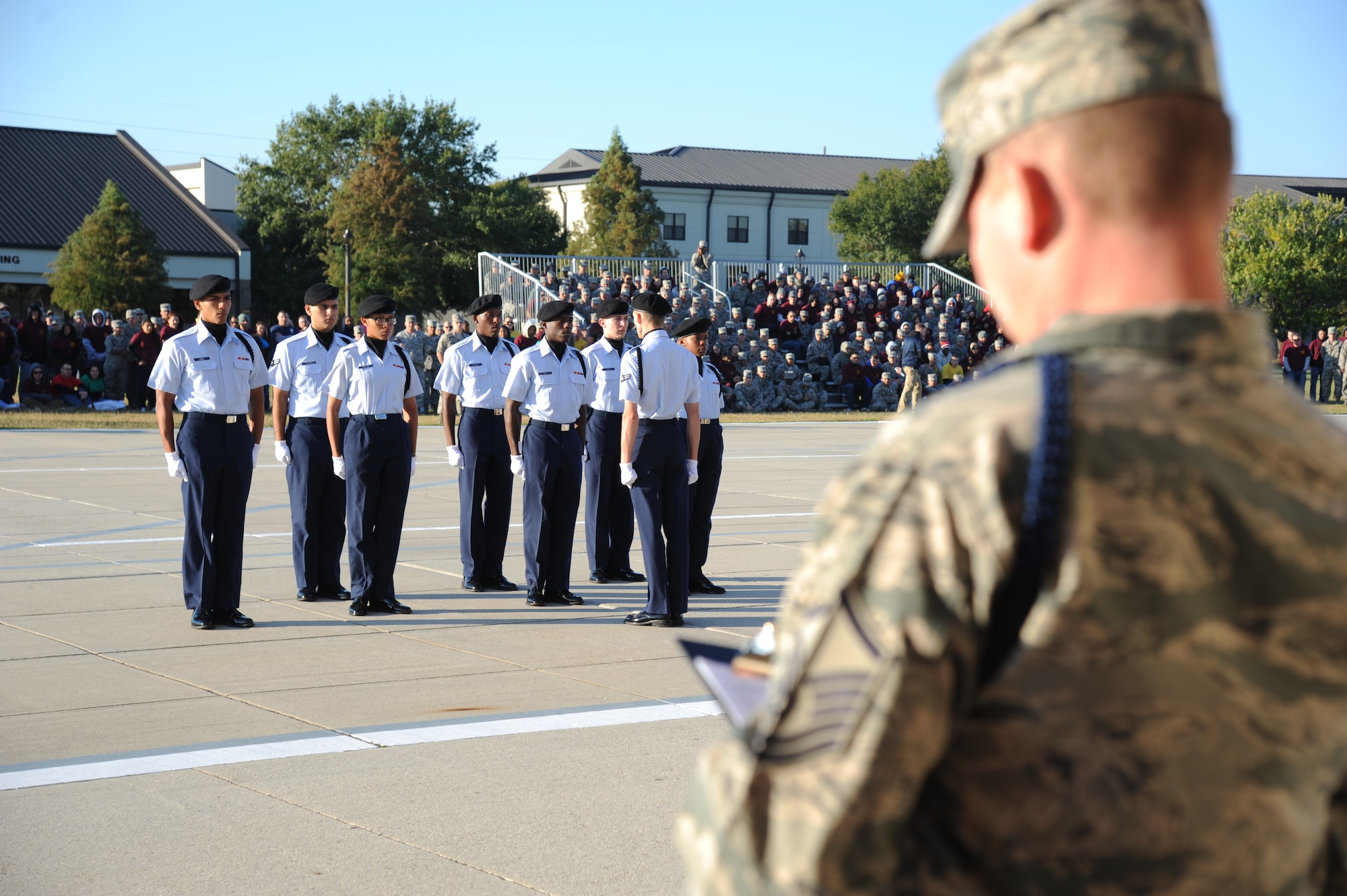 The 336th Training Squadron regulation drill team enters the field of regulation drillas Master Sgt. Michael Biss, 2nd Air Force, serves as a judge during the 81st Training Group drill down competition Oct. 25, 2013, at the Levitow Training Support Facility, Keesler Air Force Base, Miss.  The 336th TRS placed 3rd in all four categories.  (U.S. Air Force photo by Kemberly Groue)