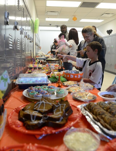 The 20th Security Forces Squadron defenders and their families help themselves to snacks after a magic show, Shaw Air Force Base, S.C., Oct. 25, 2013. 20th SFS members and their children gathered to participate in numerous games and activities, a magic show, a haunted room, and a children’s costume contest. (U.S. Air Force photo by Senior Airman Tabatha Zarrella/Released)