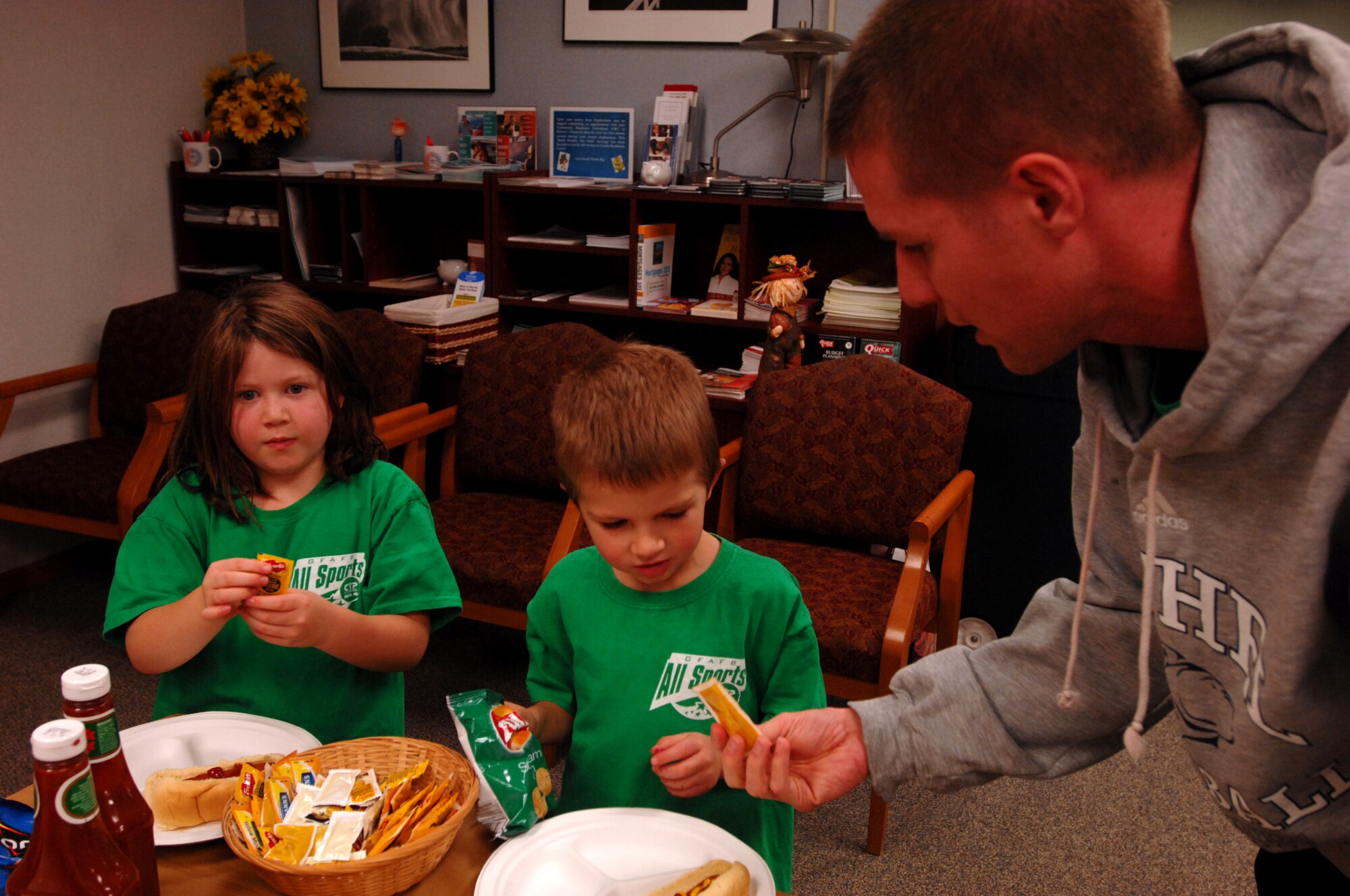Capt. Matt Moberg, 319th Medical Group, helps his son, Blaise, 5, and daughter, Coral, 6, put condiments on their hot dogs at the Airman & Family Readiness Center’s Seventh Annual Soup Supper Oct. 24, 2013 on Grand Forks Air Force Base, N.D. This year the event also hosted a special guest, columnist Marilyn Haggerty, from the Grand Forks Herald. (U.S. Air Force photo/Staff Sgt. Susan L. Davis)