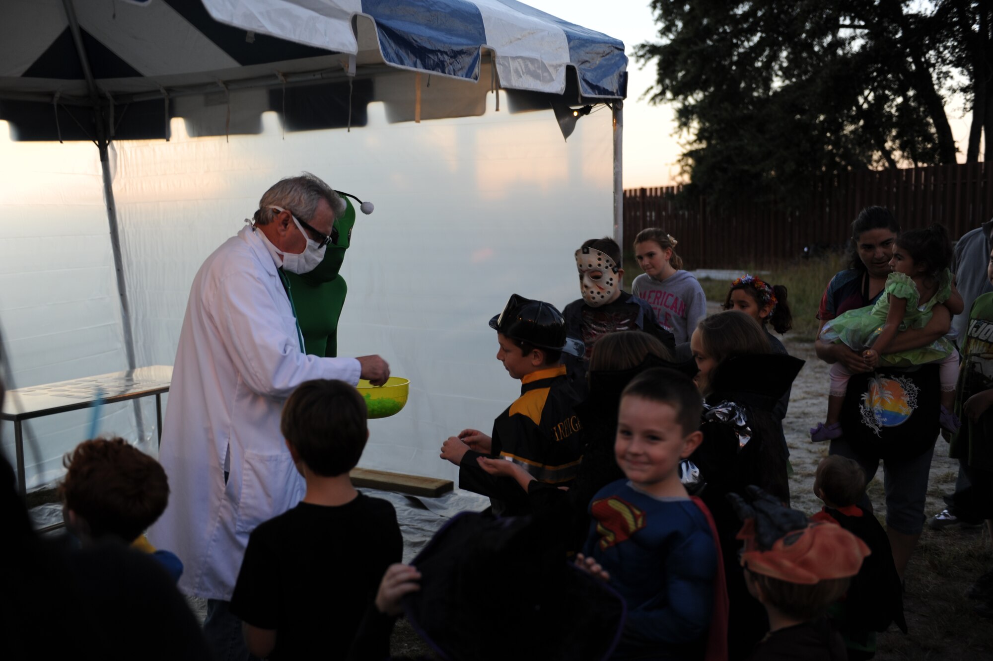 Barry Newman, 81st Training Wing SAPR office, and Mike Lacy, Sun Herald, hand out candy to children at the alien crash site during the Ghouls in the Park event at the marina park Oct. 25, 2013, Keesler Air Force Base, Miss. Various sponsors and private organizations from the base provided support and entertainment for the event, including “Trunk or Treat” by the Keesler Spouses Club, a haunted house by the Airman’s Council, and free popcorn provided by Keesler Federal Credit Union. (U.S. Air Force photo by Airman 1st Class Stephan Coleman)