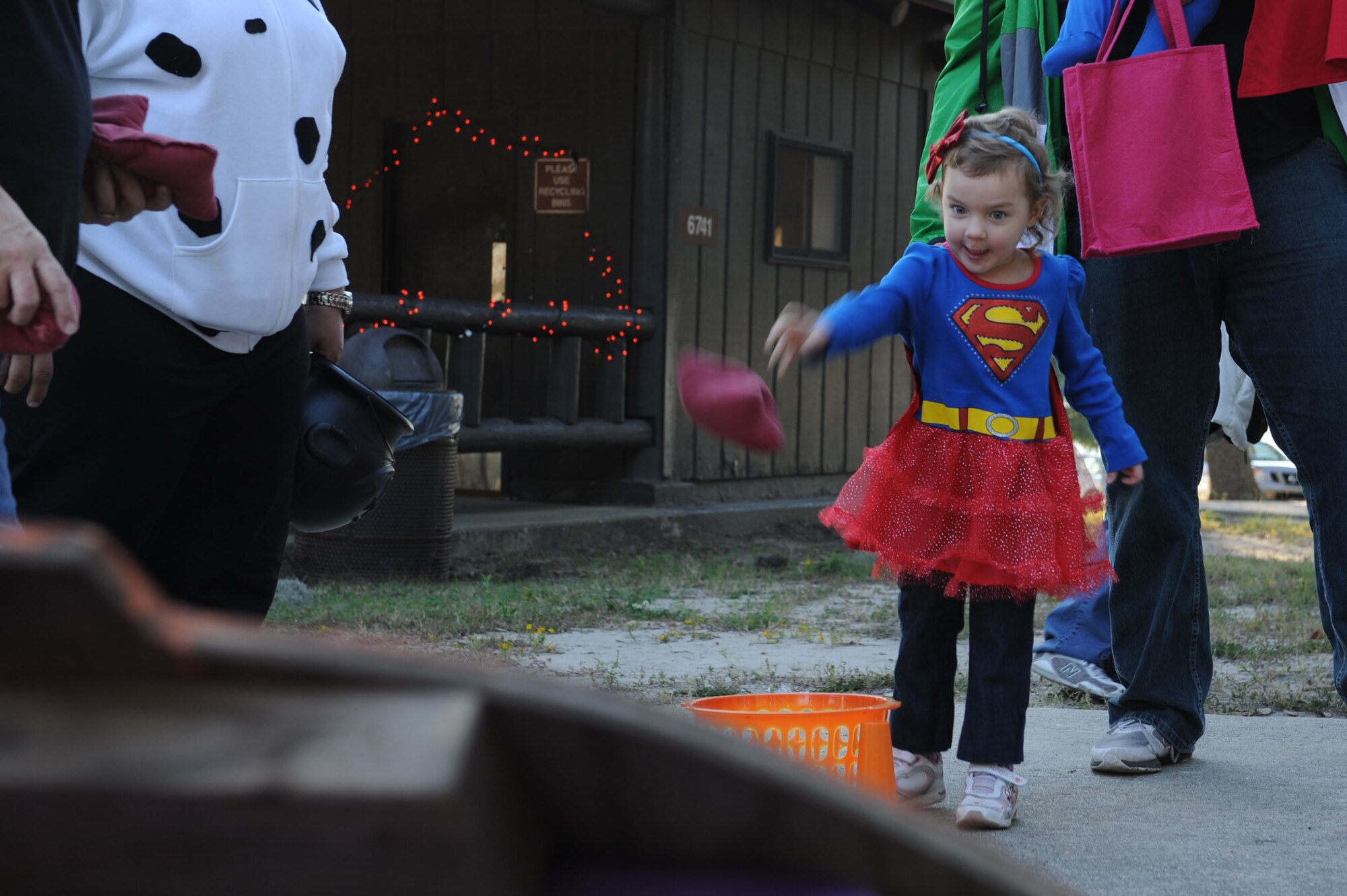 The husband and daughter Capt. Rebekah Carlisle, 81st Medical Operations Squadron, tosses a bean bag at a target during the Ghouls in the Park event at the marina park Oct. 25, 2013, Keesler Air Force Base, Miss. Various sponsors and private organizations from the base provided support and entertainment for the event, including “Trunk or Treat” by the Keesler Spouses Club, a haunted house by the Airman’s Council, and free popcorn provided by Keesler Federal Credit Union. (U.S. Air Force photo by Airman 1st Class Stephan Coleman)