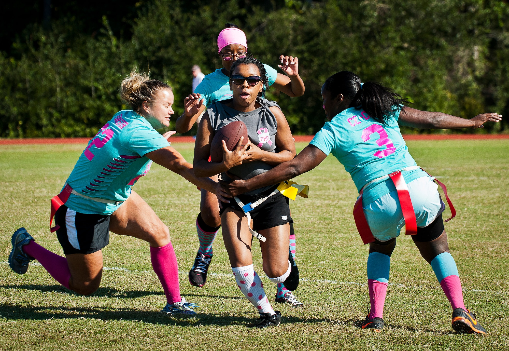 The 96th Logistics Readiness Squadron defenders try to grab the flag from the 96th Force Support Squadron runner during their powderpuff football game Oct. 25 at Eglin Air Force Base, Fla. LRS won the game 20-18. (U.S. Air Force photo/Samuel King Jr.)