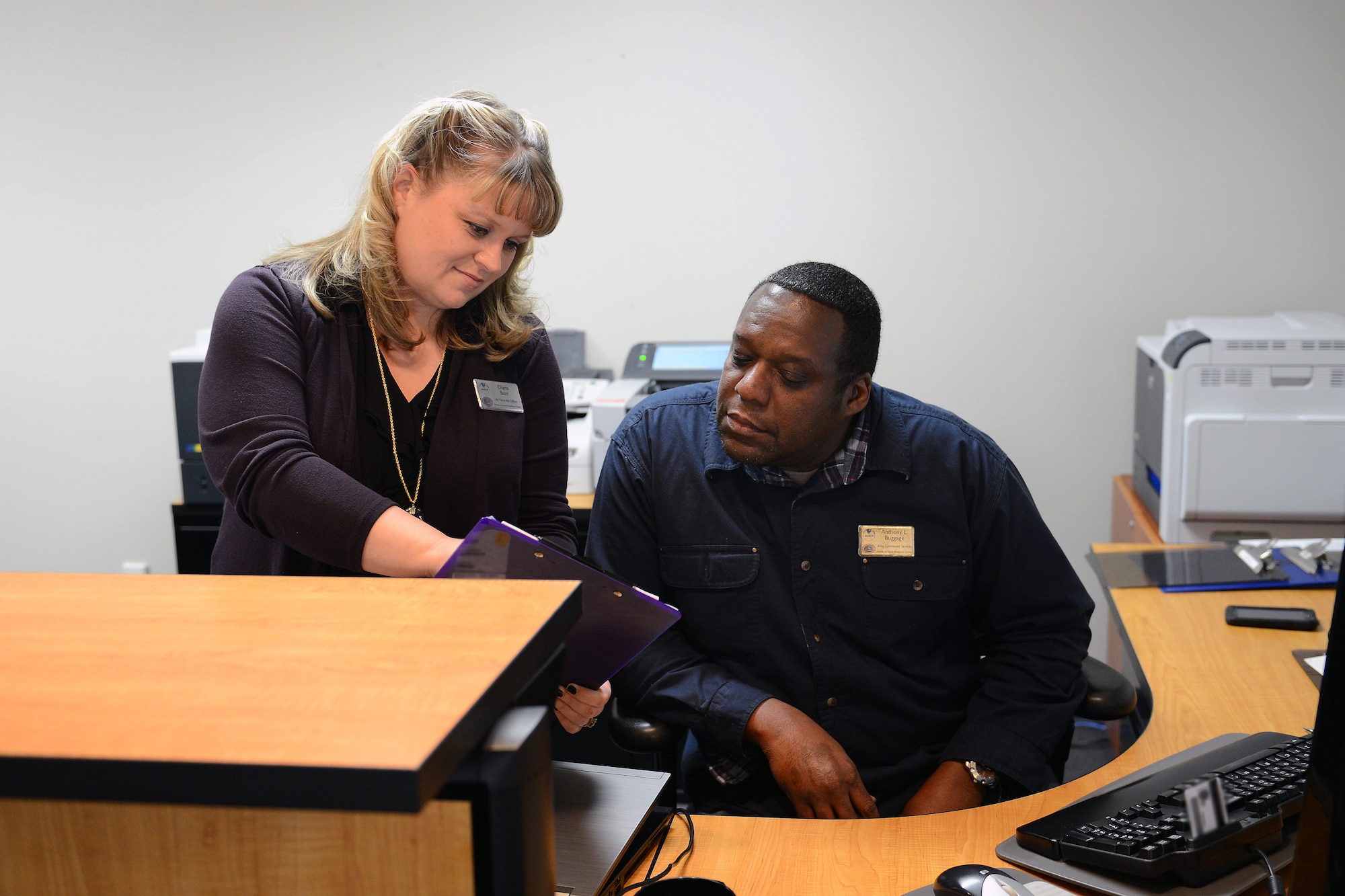 Diana Burr, Airmen and Family Readiness Center Air Force Aid officer, reviews a loan application with Anthony Buggage, community readiness consultant at the Airmen and Family Readiness Center, Oct. 18, 2013, at Joint Base Lewis-McChord, Wash. The Air Force Aid Society offers grants and interest-free loans to Airmen going through crisis. (U.S. Air Force photo/Airman 1st Class Jacob Jimenez)  