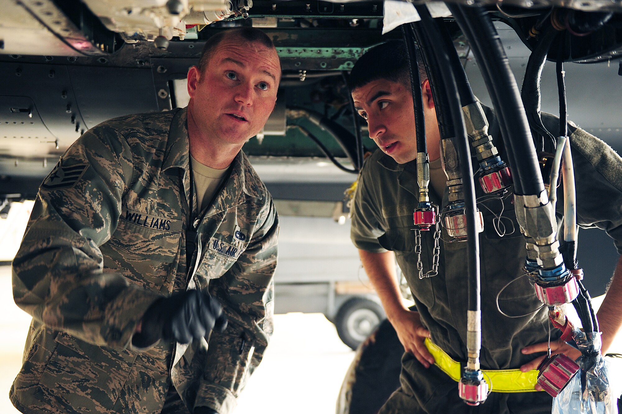 U.S. Air Force Staff Sgt. Jason Williams, 4th Maintenance Group quality assurance inspector, shows Senior Airman Gilberto Suarez, 4th Aircraft Maintenance Squadron environmental electrician, where to install a clamp on an F-15E Strike Eagle at Seymour Johnson Air Force Base, N.C., Oct. 21, 2013.  Williams won the Thomas N. Barnes Crew Chief of the Year Award for his excellence in job performance and leadership.  As a quality assurance inspector, Williams passes down his extensive knowledge of aircraft maintenance and is able to focus more on what he loves – teaching.  (U.S. Air Force photo by Airman 1st Class Brittain Crolley)