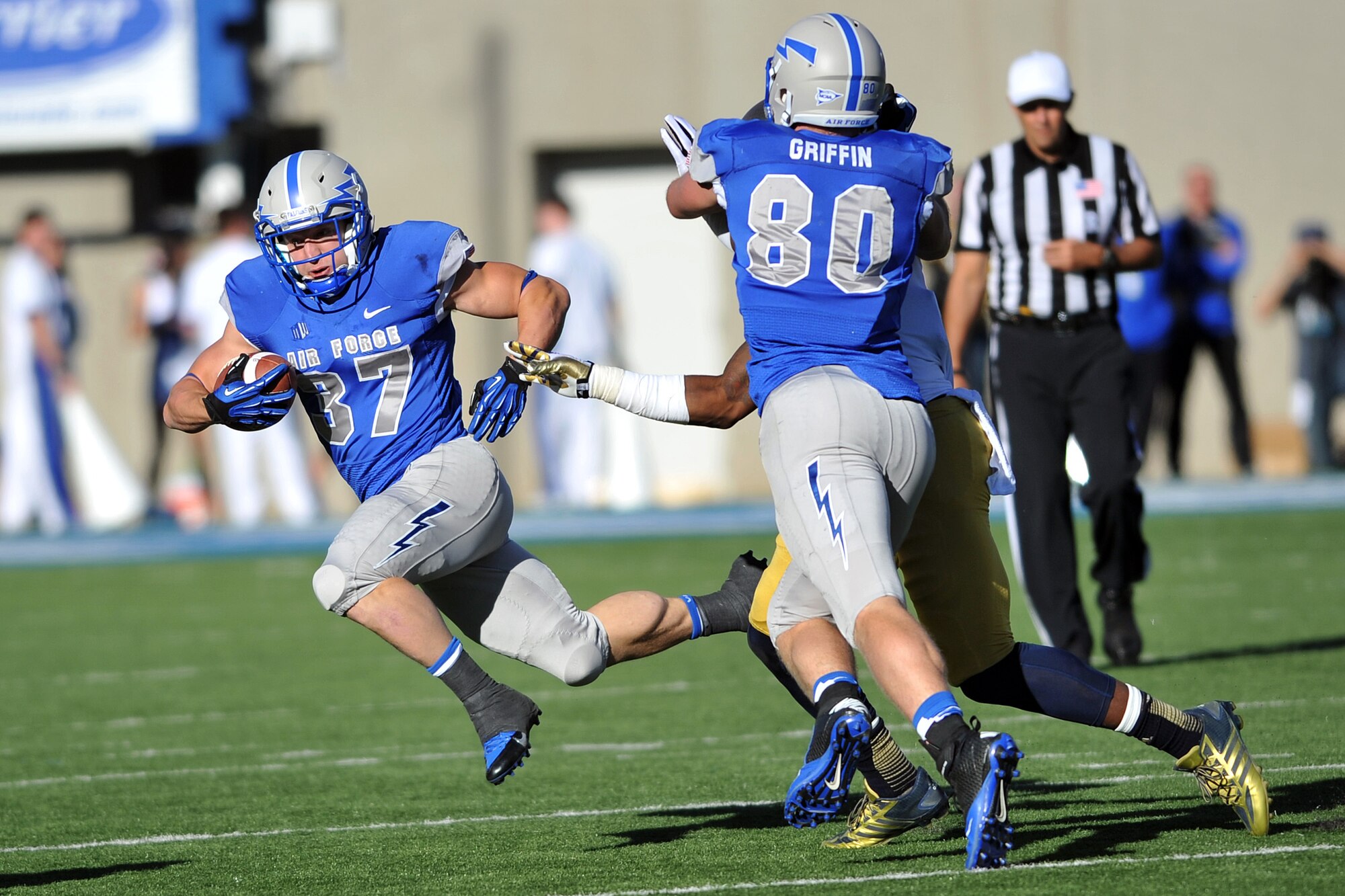 Air Force sophomore tight end Garrett Griffin blocks a Notre Dame defender as senior running back Anthony LaCoste runs to the outside during the Air Force-Notre Dame game at Falcon Stadium Oct. 26, 2013. Air Force took a 7-0 lead in the first quarter but could not find the end zone again, losing 45-10 to the Fighting Irish. LaCoste had eight rushes for 54 yards. (U.S. Air Force photo/Sam Lee)