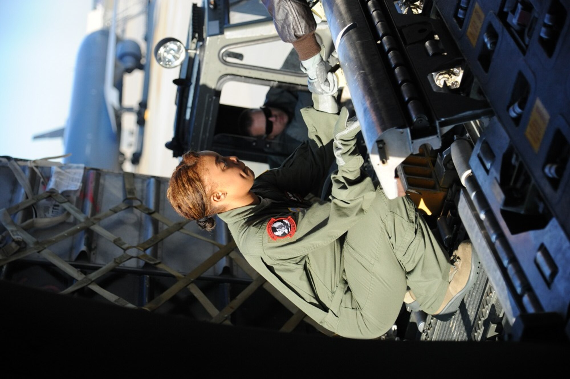 Airman 1st Class Stephanie Hodge, 2nd Air Refueling Squadron student boom operator, secures a cargo loading roller to the edge of the cargo bay before beginning a static cargo load on a KC-10 Extender Oct. 21, 2013, at Joint Base McGuire-Dix-Lakehurst, N.J. Hodge performed one of several static cargo loads necessary in the cargo phase of local boom operator training. (U.S. Air Force photo by Airman 1st Class Sean M. Crowe/Released)