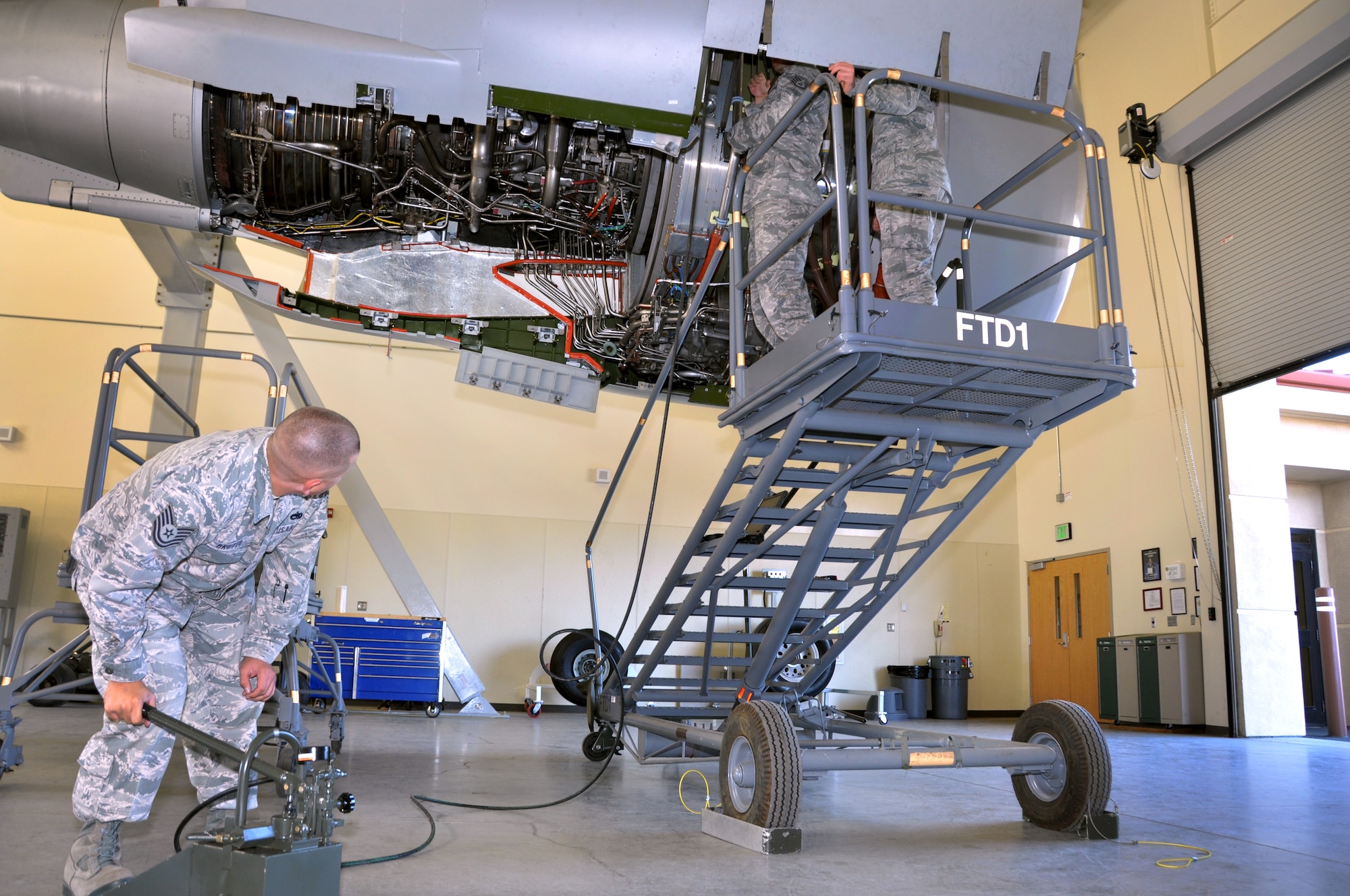Tech Sgt. Robert Brutto, 60th Aircraft Maintenance Squadron electrical/enviromental specialist uses a hand pump to open the engine door on the Aircraft Engine Maintenance TrainerOct. 18 in the 373rd TRS Det 14 C-17 training facility. (U.S. Air Force photo/Staff Sgt. Patrick Harrower)