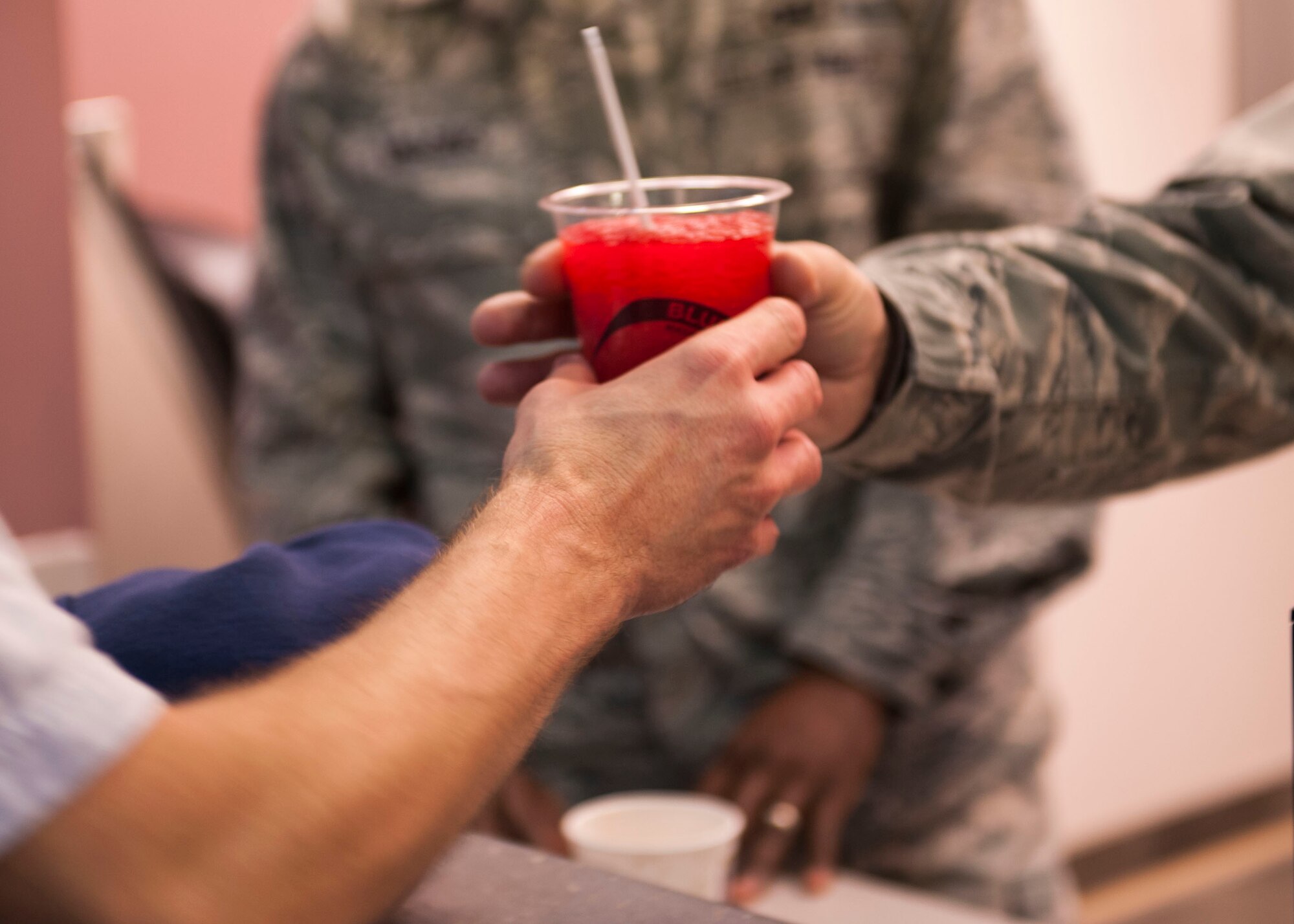 Tech Sgt. Nathaniel Jones, 5th Bomb Wing head chaplain assistant, gives an Airman a post-workout frozen drink at the McAdoo Sports and Fitness Center, Oct. 22. The base chapel staff host’s a juice bar Tuesday and Thursday mornings at the fitness center, offering free drinks, snacks and literature to boost the morale and promote resiliency for Airmen and their families. (U.S. Air Force photo/Airman 1st Class Apryl Hall)