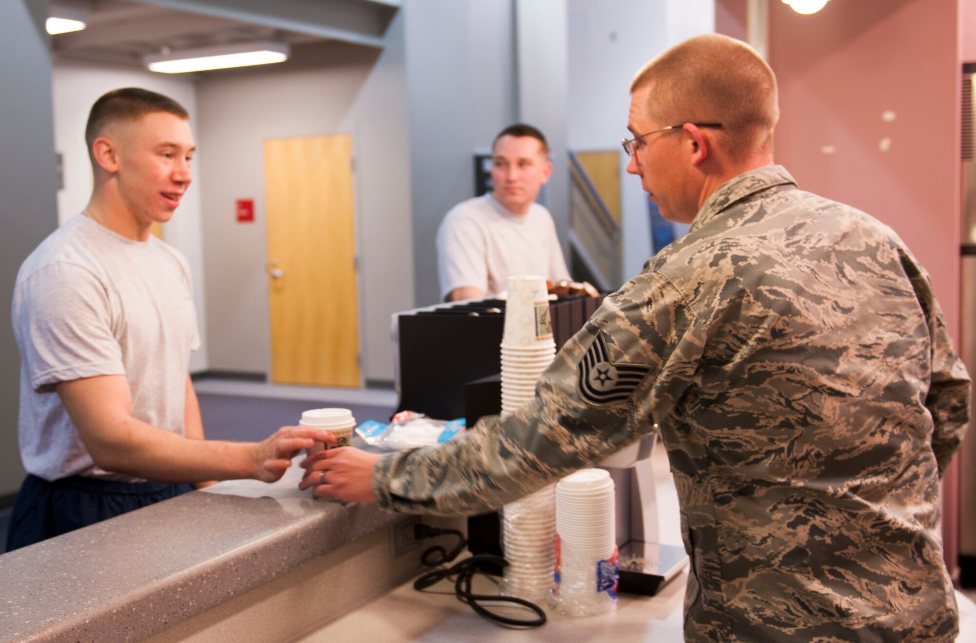 Tech Sgt. Nathaniel Jones, 5th Bomb Wing head chaplain assistant, serves coffee to an Airman at the McAdoo Sports and Fitness Center, Oct. 22. The base chapel host’s a juice bar Tuesday and Thursday mornings at the fitness center, offering free drinks, snacks and literature to boost the morale and promote resiliency for Airmen and their families. (U.S. Air Force photo/Airman 1st Class Apryl Hall)