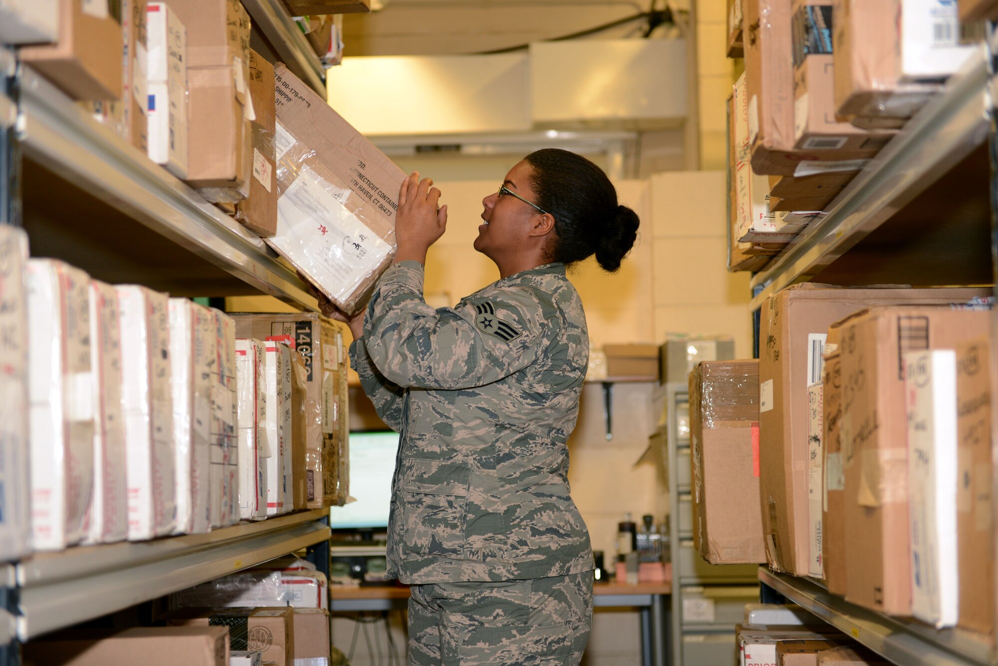 U.S. Air Force Senior Airman Taijah Rankin, 100th Communications Squadron postal clerk from Lafayette, La., pulls a package off a shelf Oct. 28, 2013, in the post office on RAF Mildenhall, England. Shipping deadlines for the holidays are quickly approaching. Team Mildenhall members are advised to do their mailing ahead of shipment deadlines for packages, letters and cards to help prevent lines and wait times. (U.S. Air Force photo by Airman 1st Class Preston Webb/Released)