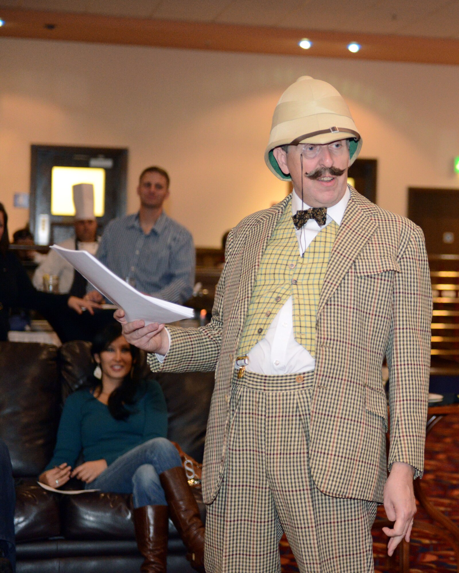 An actor portraying "Earl Graitee" announces the rules for a limerick contest during a murder mystery theater production Oct. 25, 2013, in the Galaxy Club on RAF Mildenhall, England. The writer of the best limerick won a box of chocolates at the end of the evening. The production, hosted by the 100th Force Support Squadron, was one of this year's many Halloweek activities. (U.S. Air Force photo by Airman 1st Class Preston Webb/Released)