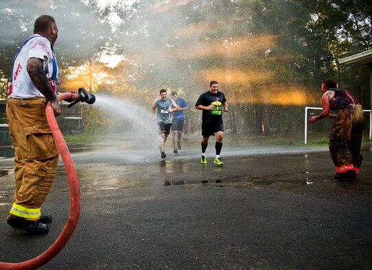 Zombie firefighters hose down and attack runners at the end of the 2nd Annual Zombie Run Oct. 26 at the Eglin Air Force Base golf course.  More than 500 people attempted to outrun zombies and maneuver through various obstacles along the four-mile course.  (U.S. Air Force photo/Samuel King Jr.)