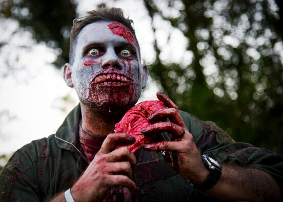 A zombie dines on the brain of some unlucky runner during the 2nd Annual Zombie Run Oct. 26 at the Eglin Air Force Base golf course.  More than 500 people attempted to outrun zombies and maneuver through various obstacles along the four-mile course.  (U.S. Air Force photo/Samuel King Jr.)