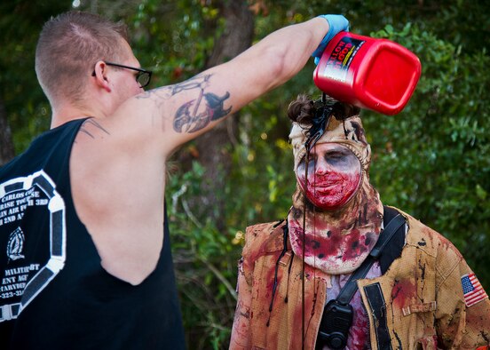 An Eglin firefighter gets doused in fake blood prior to the 2nd Annual Zombie Run Oct. 26 at the Eglin Air Force Base golf course.  More than 500 people attempted to outrun zombies and maneuver through various obstacles along the four-mile course.  (U.S. Air Force photo/Samuel King Jr.)