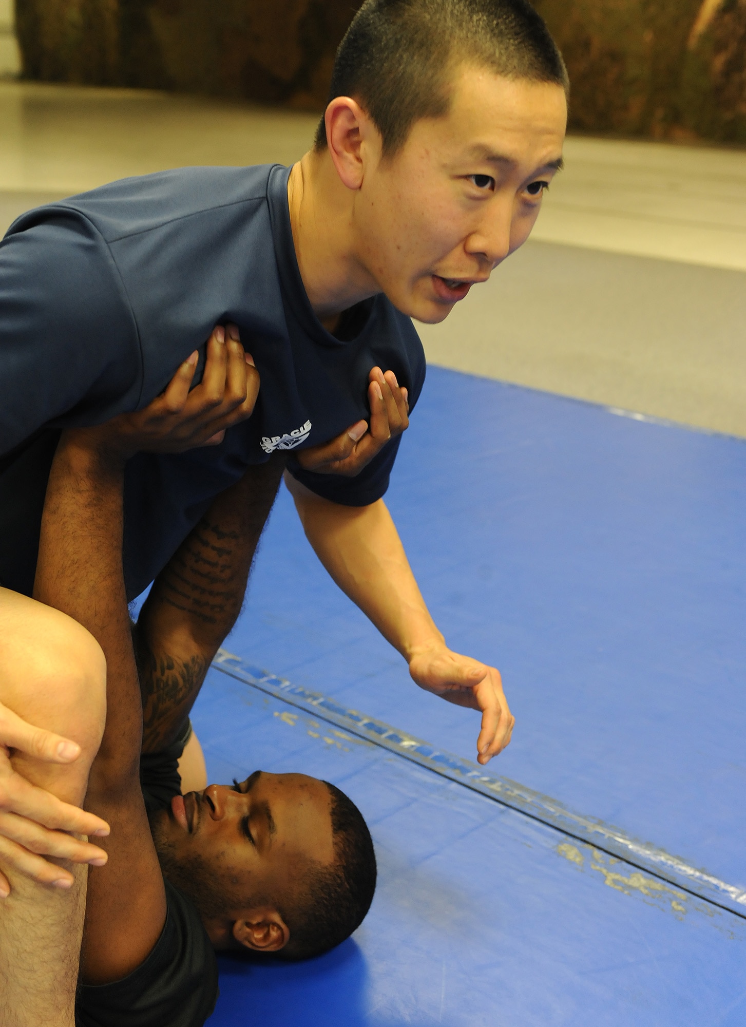 Senior Airman Kyle Larrow, 5th Security Forces Squadron confinement guard, lifts Senior Airman James Hong, 5th Communications Squadron cyber systems operator, as part of an arm bar demonstration during Jiu Jitsu training at Minot Air Force Base, N.D., Oct. 22. Larrow has been attending Gracie Jiu Jitsu classes since June 2013. (U.S. Air Force photo/Senior Airman Stephanie Sauberan)