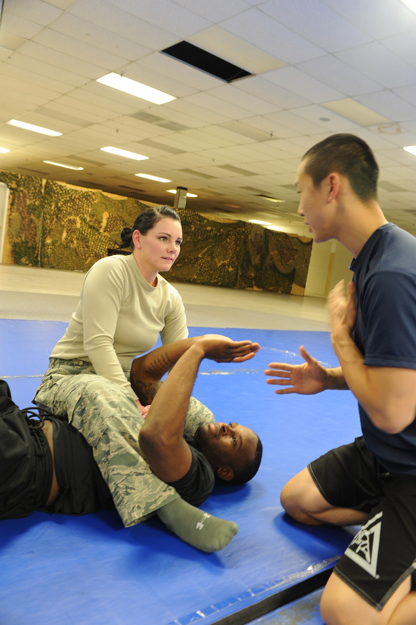 Senior Airman James Hong, 5th Communications Squadron cyber systems operator, instructs Airman 1st Class Laura McDuffie, 5th CS cyber transport technician, on the arm bar technique during Jiu Jitsu training at Minot Air Force Base, N.D., Oct. 22. McDuffie applies skills she learned while on her high school wrestling team in Tallahassee, F.L., to her training in the Gracie Jiu Jitsu program. (U.S. Air Force photo/Senior Airman Stephanie Sauberan)