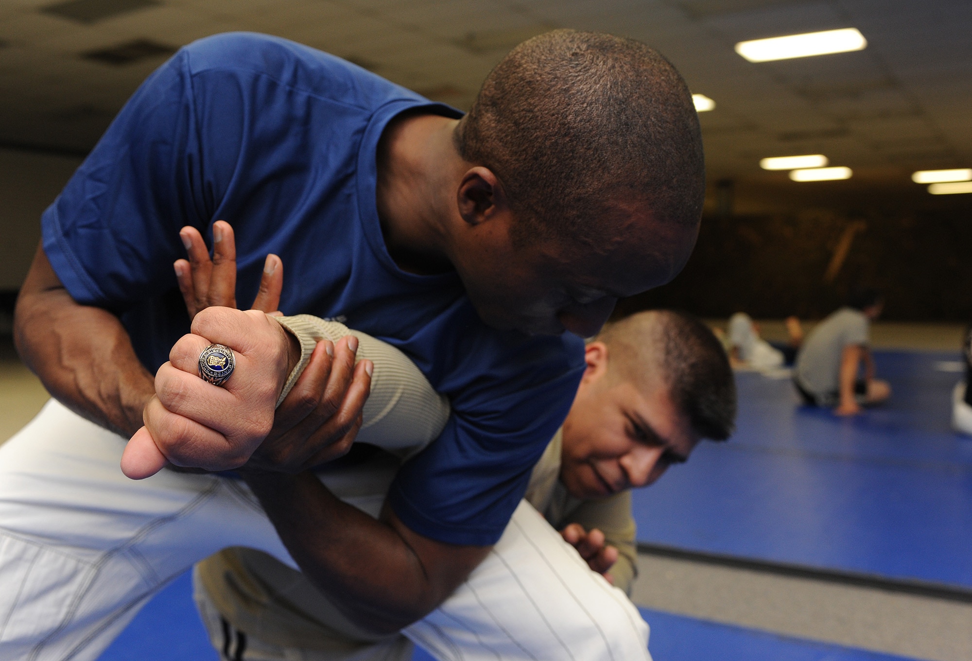 Maj. Tyrone Bess, 5th Security Forces Squadron deputy commander, applies a standing arm lock to Tech. Sgt. Tony Cortinas, 5th Bomb Wing director of equal opportunity, during Jiu Jitsu training at Minot Air Force Base, N.D., Oct. 22. Bess has been instructing for more than five years with no plans of stopping in the near future. (U.S. Air Force photo/Senior Airman Stephanie Sauberan)