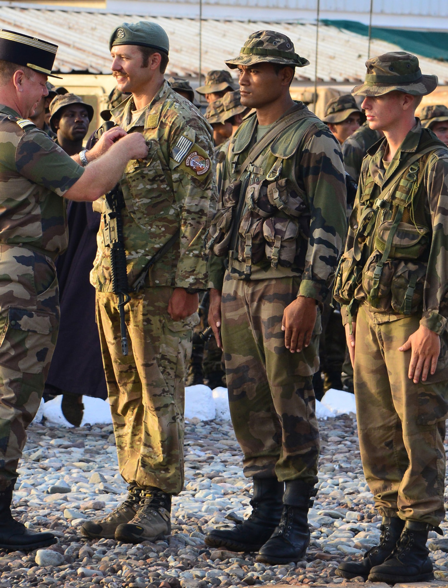 CAMP LEMONNIER, Djibouti -- U.S. Air Force Reservist Staff Sgt. Benjamin Domian, a SERE specialist with the 920th Rescue Wing, is awarded a French desert combat badge during a graduation ceremony near Camp Lemonnier, Djibouti, Oct. 16, 2013. Sergeant Domian was named honor graduate of the more than 160 French and U.S. military members who participated in the 10-day desert combat course, with about 143 completing the test of mental and physical obstacles in the Djiboutian desert. Joint training, such as this, builds relationships with partner nations and ensures Combined Joint Task Force-Horn of Africa members are continually ready to support military operations in East Africa to defeat violent extremist organizations. (U.S. Air Force photo by Tech. Sgt. Chad Thompson)
