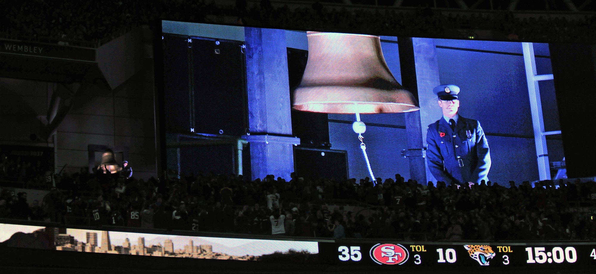 A Royal Air Force senior aircraftman rings the bell during the third quarter of the Jacksonville Jaguars versus San Francisco 49ers National Football League game Oct. 27, 2013, at Wembley Stadium in London, England. The bell was rung four times in honor of men and women, both past and present, serving their countries. The NFL gave U.S. Air Force Airman 1st Class James Taylor, 100th Security Forces Squadron patrolman, and U.S. Air Force Airman Sara V. Summers, 48th Security Forces Squadron patrolman from RAF Lakenheath, the opportunity to lead rival football teams onto the field. (U.S. Air Force photo by Senior Airman Christine Griffiths/Released)