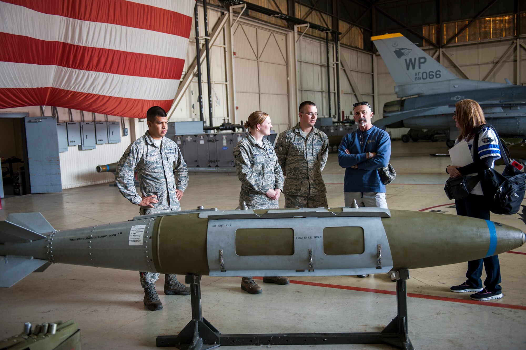 Airmen from the 8th Maintenance Group brief country music artist Aaron Tippin on aircraft weapons during a tour at Kunsan Air Base, Republic of Korea, Oct. 25, 2013. Tippin performed at several military bases around Korea in a tour sponsored by Armed Forces Entertainment and Stars for Stripes. (U.S. Air Force photo by Senior Airman Clayton Lenhardt/Released)