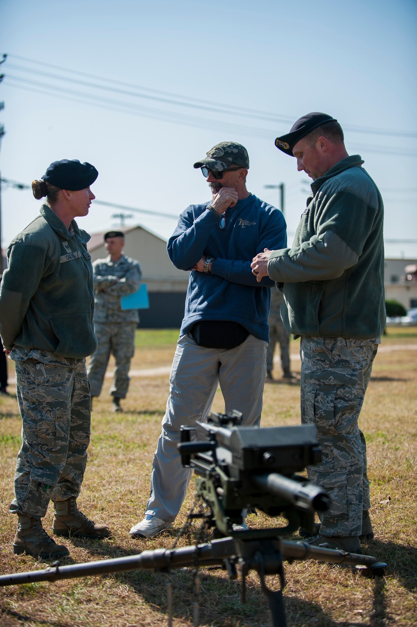 Staff Sgt. Nicole Ogilvie and Tech Sgt. Michael Oliver, 8th Security Forces Squadron, brief country music artist Aaron Tippin on weapons training at Kunsan Air Base, Republic of Korea, Oct. 25, 2013. Tippin performed at several military bases around Korea in a tour sponsored by Armed Forces Entertainment and Stars for Stripes. (U.S. Air Force photo by Senior Airman Clayton Lenhardt/Released)