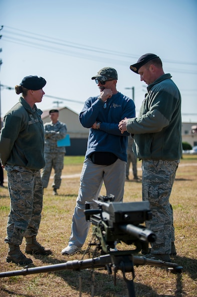 Staff Sgt. Nicole Ogilvie and Tech Sgt. Michael Oliver, 8th Security Forces Squadron, brief country music artist Aaron Tippin on weapons training at Kunsan Air Base, Republic of Korea, Oct. 25, 2013. Tippin performed at several military bases around Korea in a tour sponsored by Armed Forces Entertainment and Stars for Stripes. (U.S. Air Force photo by Senior Airman Clayton Lenhardt/Released)