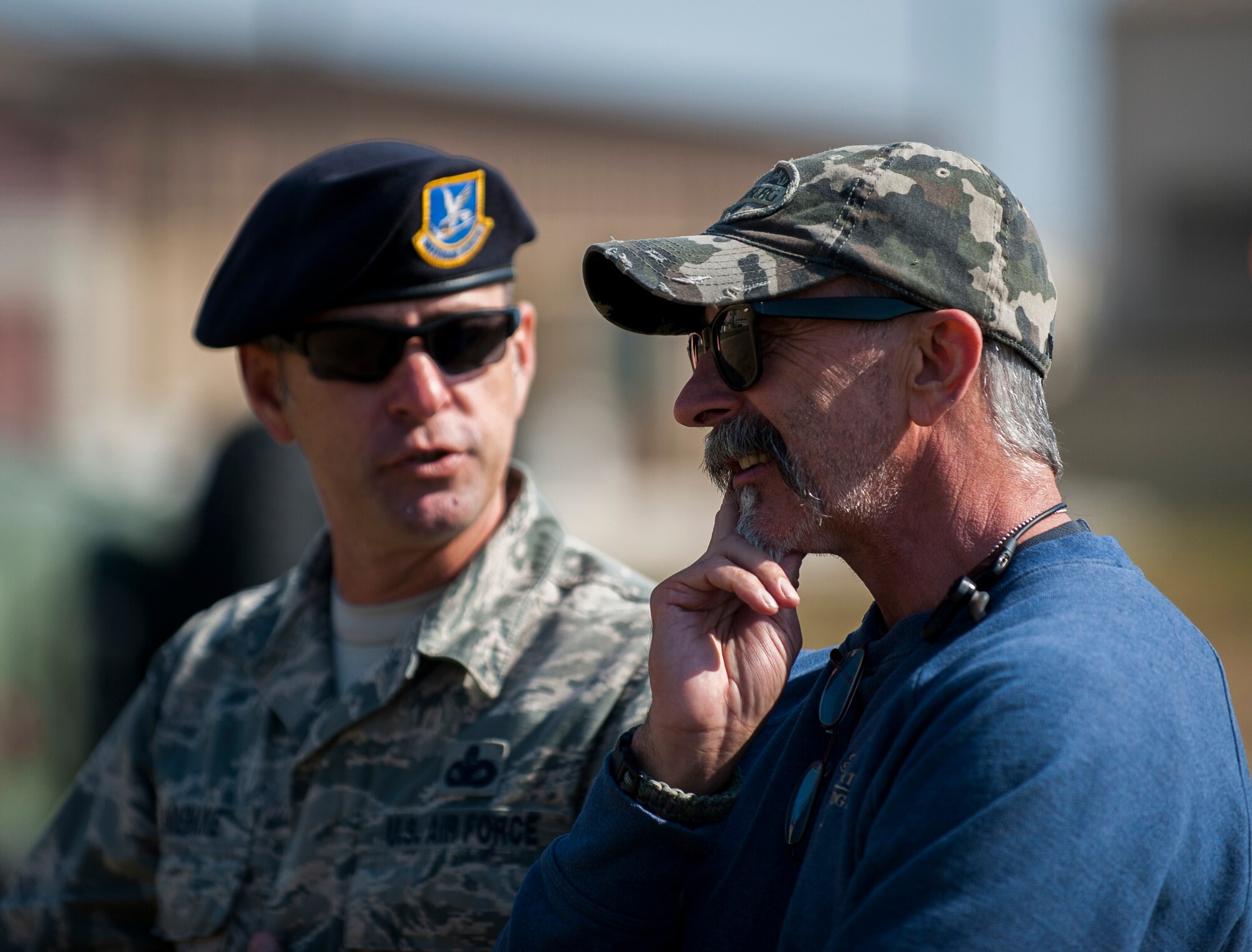 Master Sgt. Robert Shoemake, 8th Security Forces Squadron, speaks with country music artist Aaron Tippin during a military working dog demonstration at Kunsan Air Base, Republic of Korea, Oct. 25, 2013. Tippin performed at several military bases around Korea in a tour sponsored by Armed Forces Entertainment and Stars for Stripes. (U.S. Air Force photo by Senior Airman Clayton Lenhardt/Released)