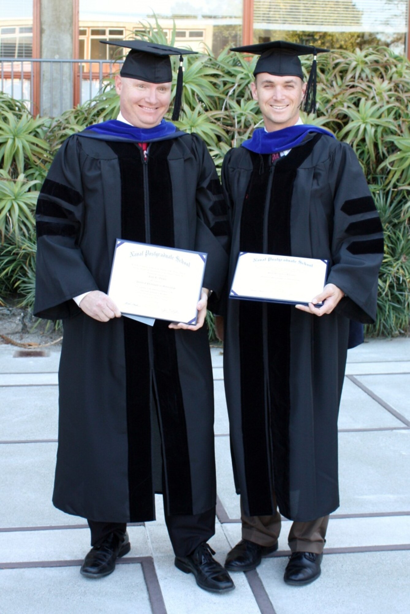 MONTEREY, Calif. -- Lt. Col. Jack Evans and Maj. Paul Homan pose for a photo after graduating from the Naval Postgraduate School with a doctorate of philosophy in meteorology. Also earning his doctorate was Lt. Col. Robert Stenger, who graduated in absentia. (Courtesy photo)