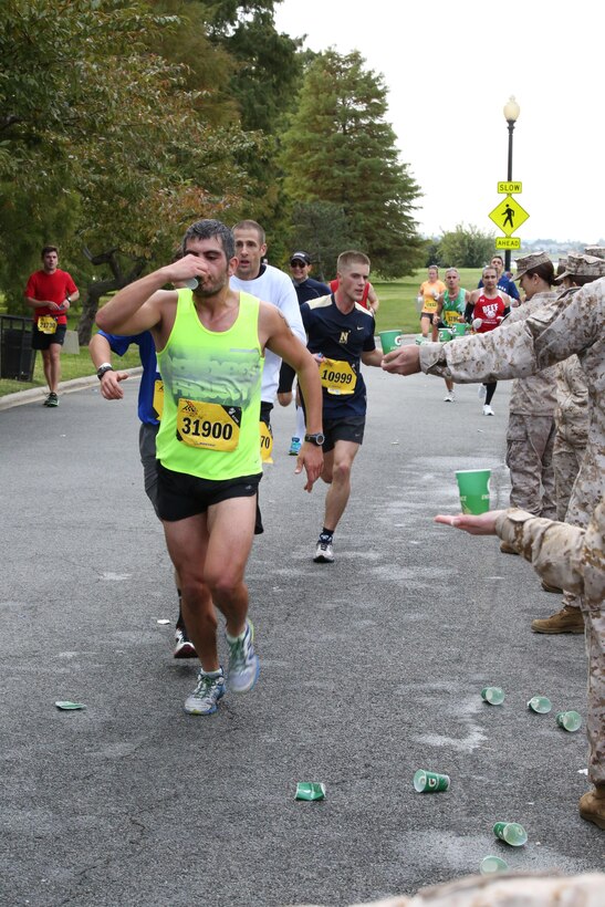 Runners drink fluids during the Marine Corps Marathon in Washington, D.C., Oct. 27, 2013. Marines and civilian volunteers handed out water and sports drinks during the 26.2-mile event.