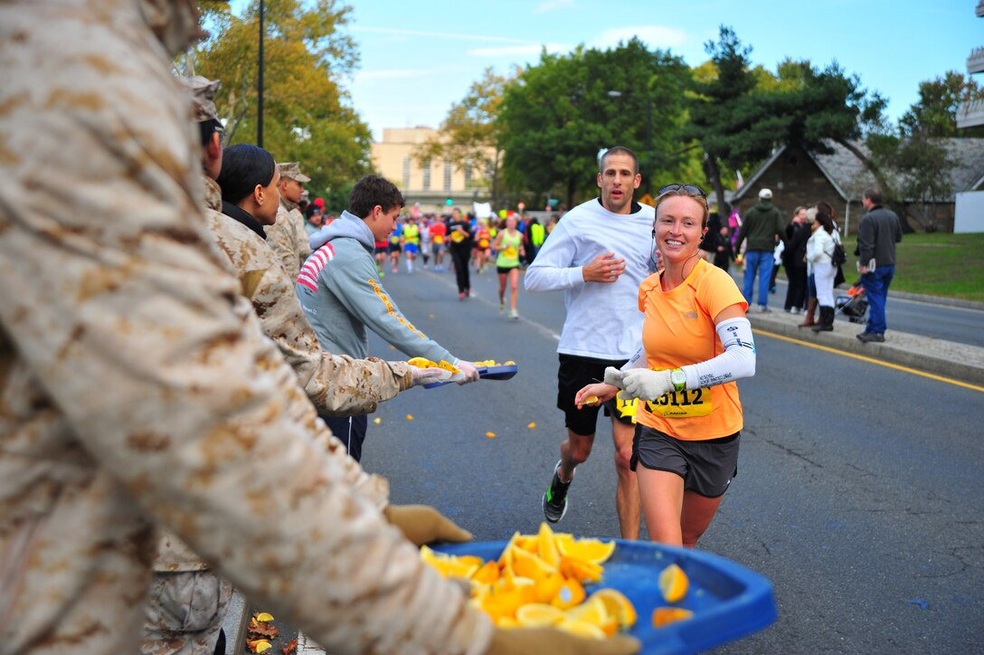 Marathon runners reach for a slice of orange to recharge their energy at the first food station during the Marine Corps Marathon in Washington, D.C., Oct. 27, 2013. The 26.2-mile event is the fifth largest U.S. marathon and ninth largest in the world. Known as the "People's Marathon," the race includes runners from all over the United States and more than 50 counties. 