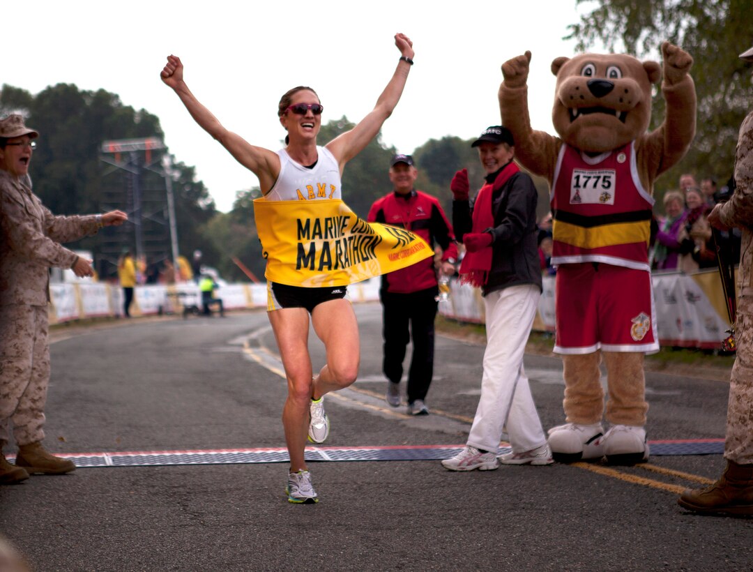 Army Capt. Kelly Calway, first place finisher for the female category, celebrates as she crosses the finish line at the Marine Corps Marathon in Washington, D.C., Oct. 27, 2013.