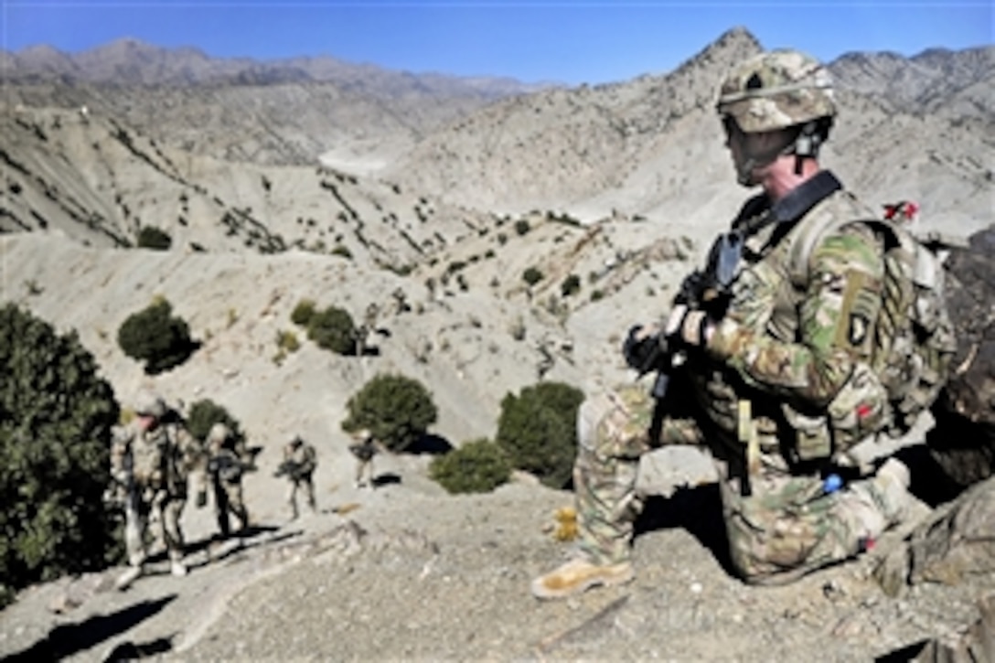 U.S. Army Pfc. Travis McGehee, right foreground, provides security from a ridge as U.S. and Afghan soldiers patrol in Afghanistan's mountainous Paktia province, Oct. 21, 2013. McGehee, an infantryman, is assigned to the 101st Airborne Division's 1st Battalion, 506th Infantry Regiment , 4th Brigade Combat Team.