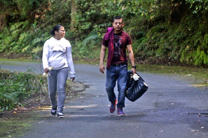 Corporals Alice Garcia and Jesus Obregon, community relations event volunteers, walk to find trash during the Single Marine Program Marine Lounge volunteer cleanup, which took place near the surrounding Futashika River area Oct. 19, 2012. Volunteers spent the entire afternoon cleaning up the environment, taking photos and enjoying a barbecue.