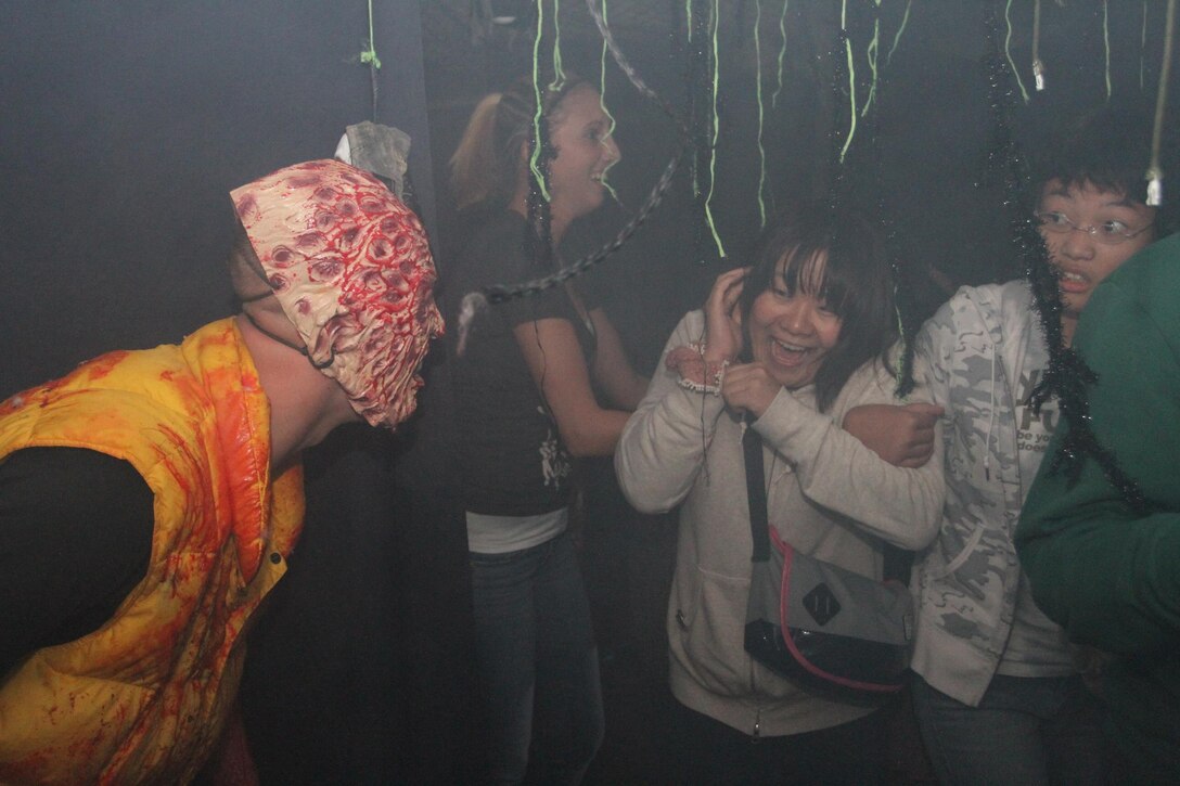 A ghoul pops up to scare Japanese visitors who scream fanatically during the Marine Wing Support Squadron 171 haunted house in the Motor Transportation building here Oct. 27, 2012. Before entering the building, those intent to enter had to listen to the screams of the groups before them over loud speakers set up outside the Motor Transportation building, building the anticipation of what was to come.