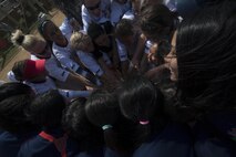 Softball players from Team Urasoe and Ryukyu Ruckus join together in a group cheer Oct. 26 following a game at Camp Kinser. The event was the first of its kind for both teams, and all the athletes hope there will be many more, according to Jamie Emery, head coach for Ryukyu Ruckus, which is based out of Camp Kinser. The competitive game ended in a tie and built friendships between members of the Urasoe and Kinser community. 