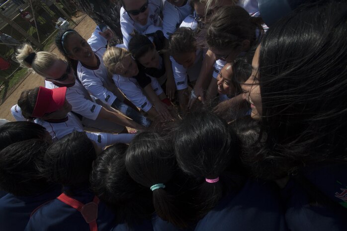 Softball players from Team Urasoe and Ryukyu Ruckus join together in a group cheer Oct. 26 following a game at Camp Kinser. The event was the first of its kind for both teams, and all the athletes hope there will be many more, according to Jamie Emery, head coach for Ryukyu Ruckus, which is based out of Camp Kinser. The competitive game ended in a tie and built friendships between members of the Urasoe and Kinser community. 