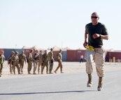 GySgt. Ruben Aguilar finishes the last 100 meters of the 2013 Marine Corps Marathon Forward at Camp Leatherneck, Afghanistan Oct. 27. Aguilar was the only runner to complete the marathon wearing boots and camoflauge utilities. (Photo by Sgt. Bobby J. Yarbrough)